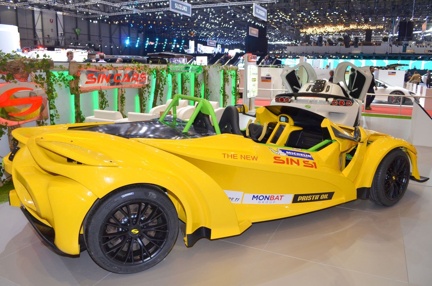 Yellow open-top sports vehicle with black wheels and green roll cage