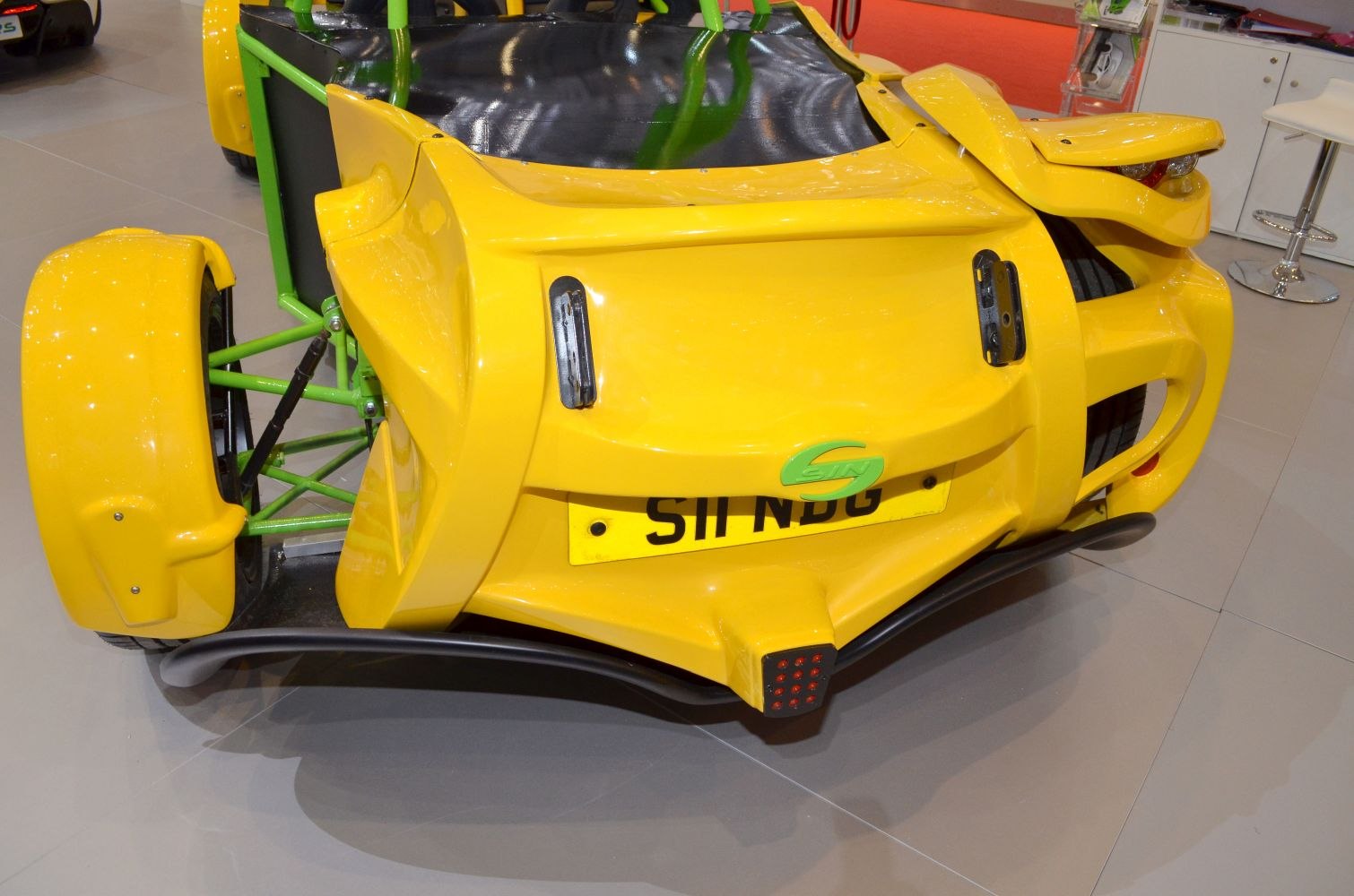 Distinctive yellow rear with exposed green tubular frame and aerodynamic fenders