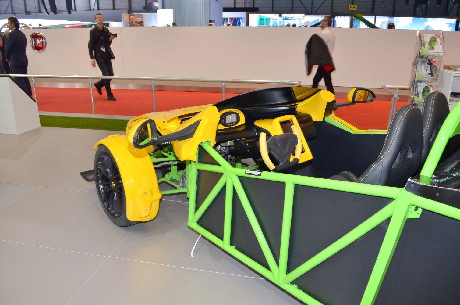 Open-wheel sports car with green tubular frame and yellow-black interior.