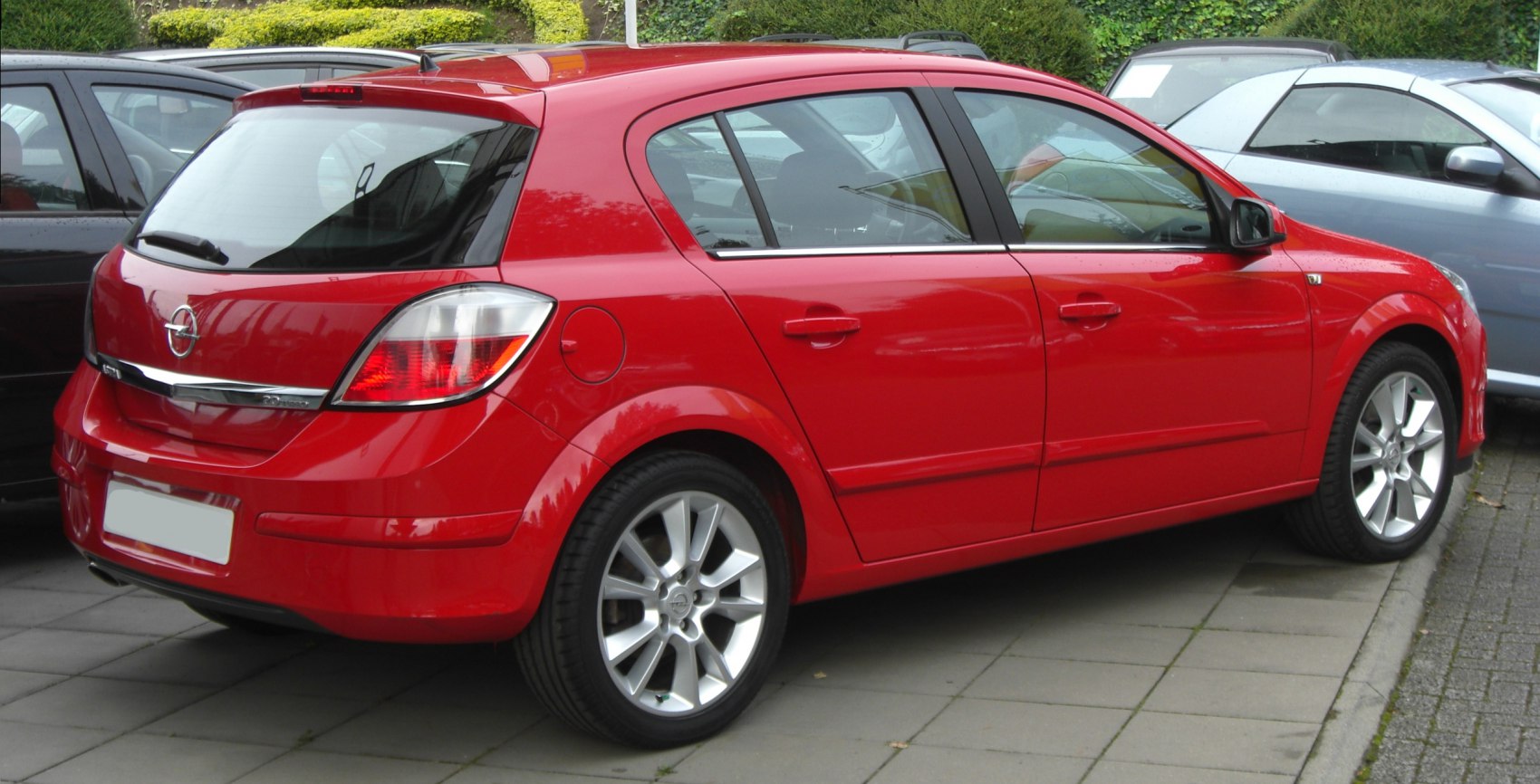 Rear-side view of red hatchback showing taillights and alloy wheels