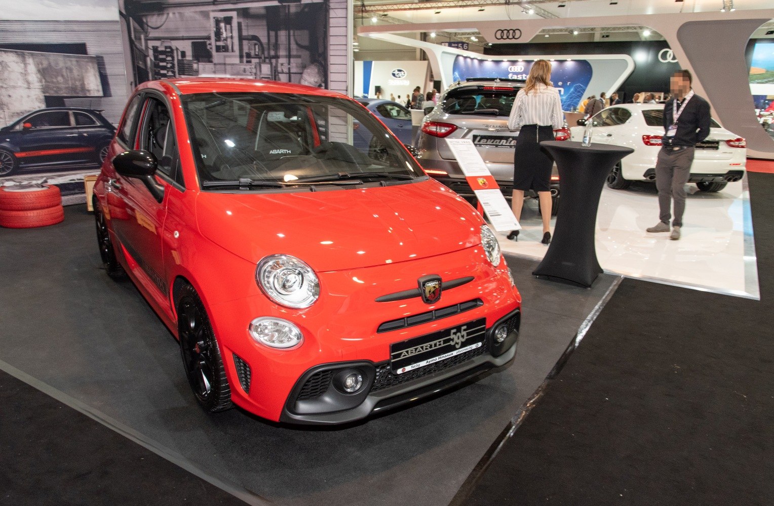Red sporty compact hatchback front view with round headlights and black accents