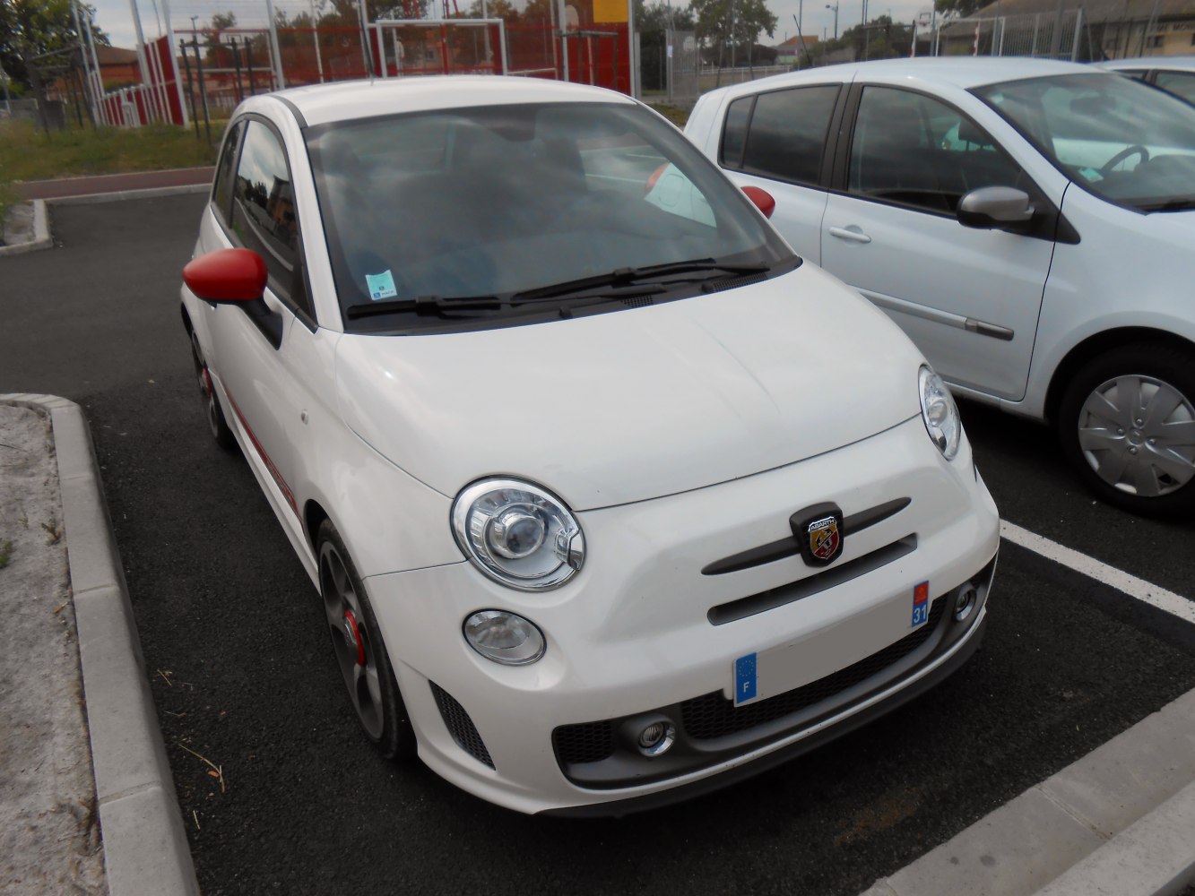 Sporty front bumper and red side mirrors on compact hatchback