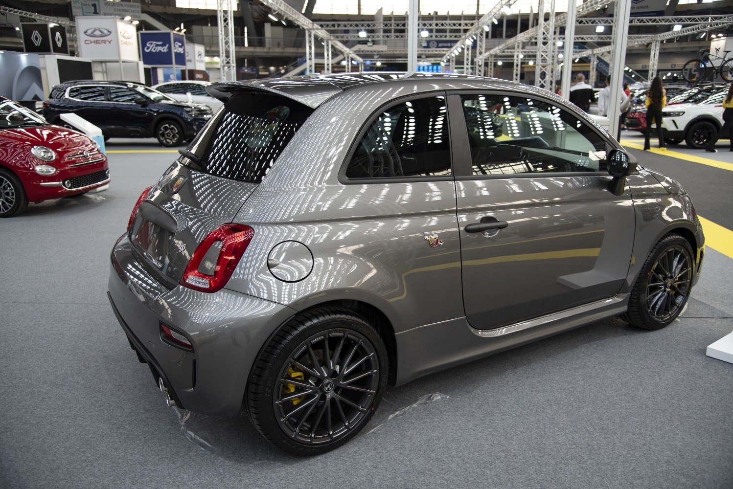 Rear-side view of a gray sporty compact hatchback with alloy wheels and diffuser