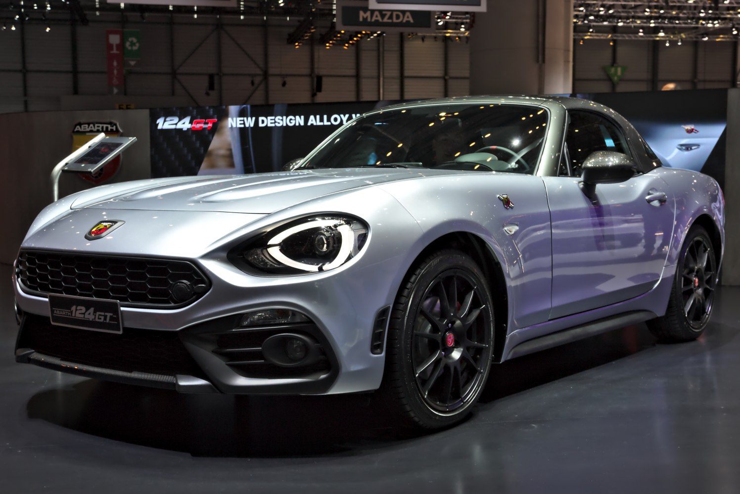 Silver sports coupe with black multi-spoke alloy wheels and distinctive front headlights