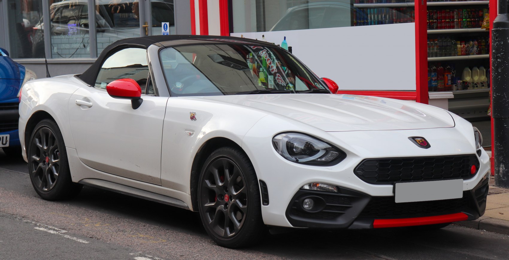Convertible with red side mirrors, black soft top, and black alloy wheels