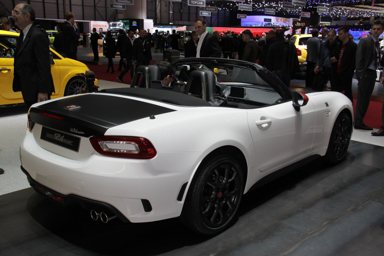 White convertible with black soft top and dual exhausts