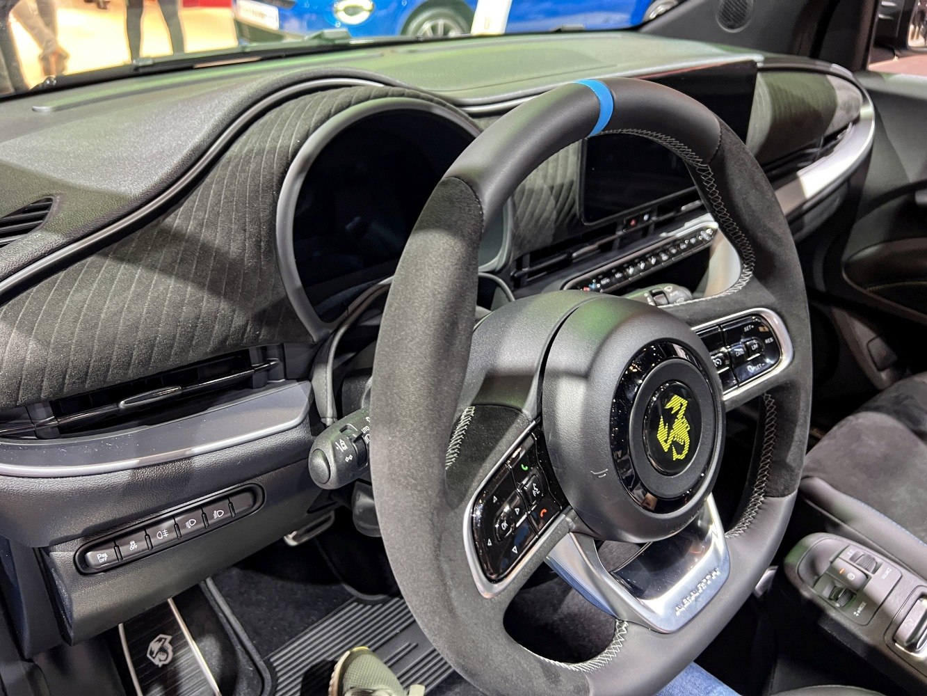 Sporty steering wheel with integrated controls and textured dashboard