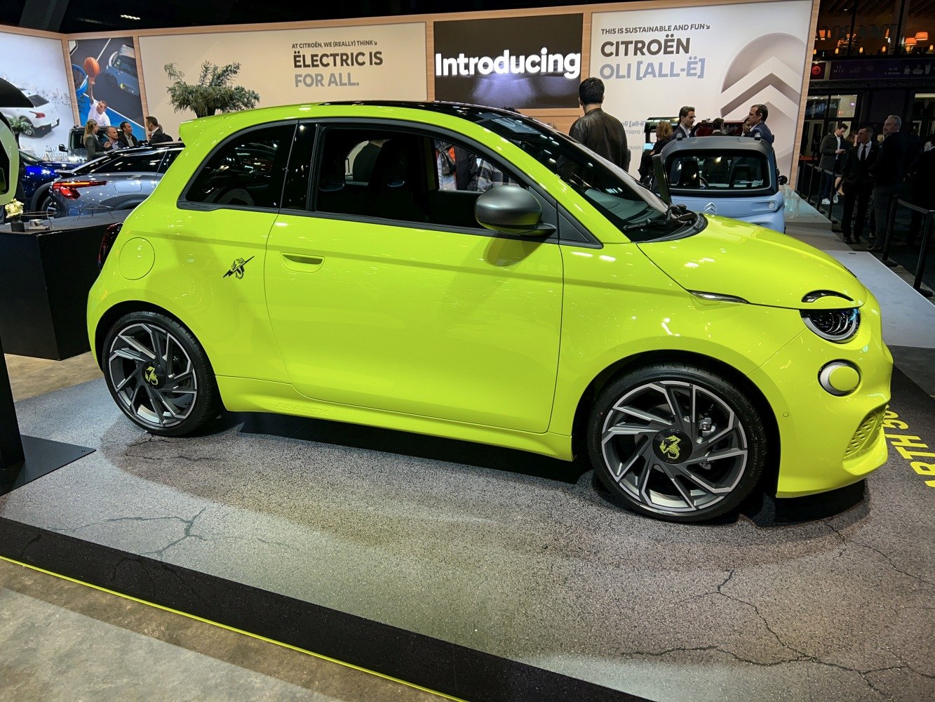 Side view of lime green electric hatchback with sporty wheels and sleek headlights