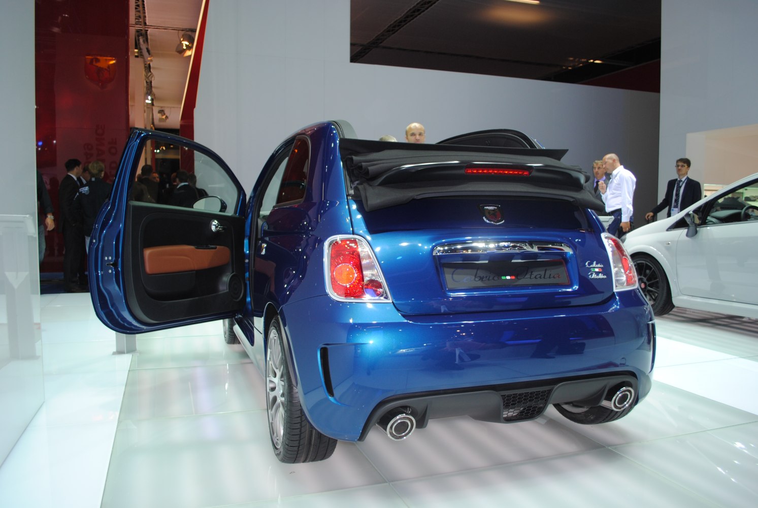 Rear view of blue convertible with open door and folded soft top