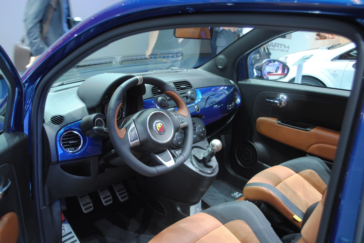 Leather-trimmed steering wheel and manual gearstick in sporty car interior