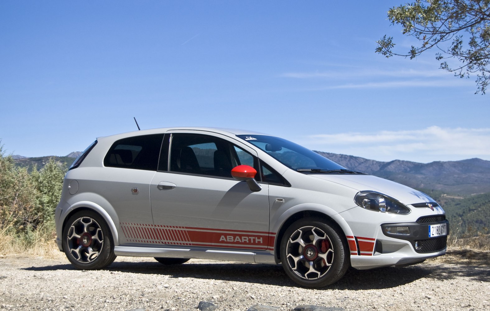 White sporty hatchback with red side stripes and red mirror caps