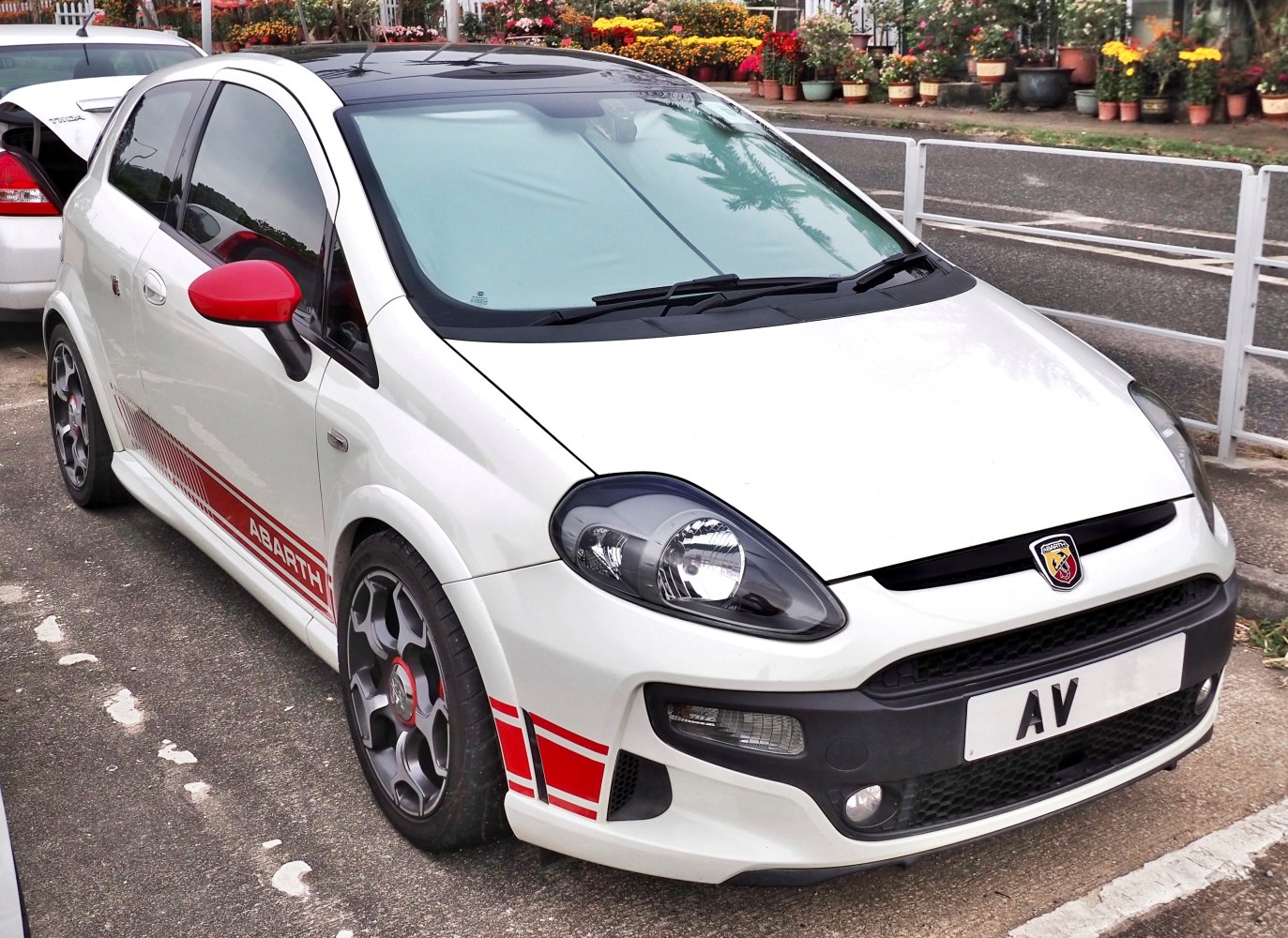 Sporty hatchback with red side mirrors and racing stripes