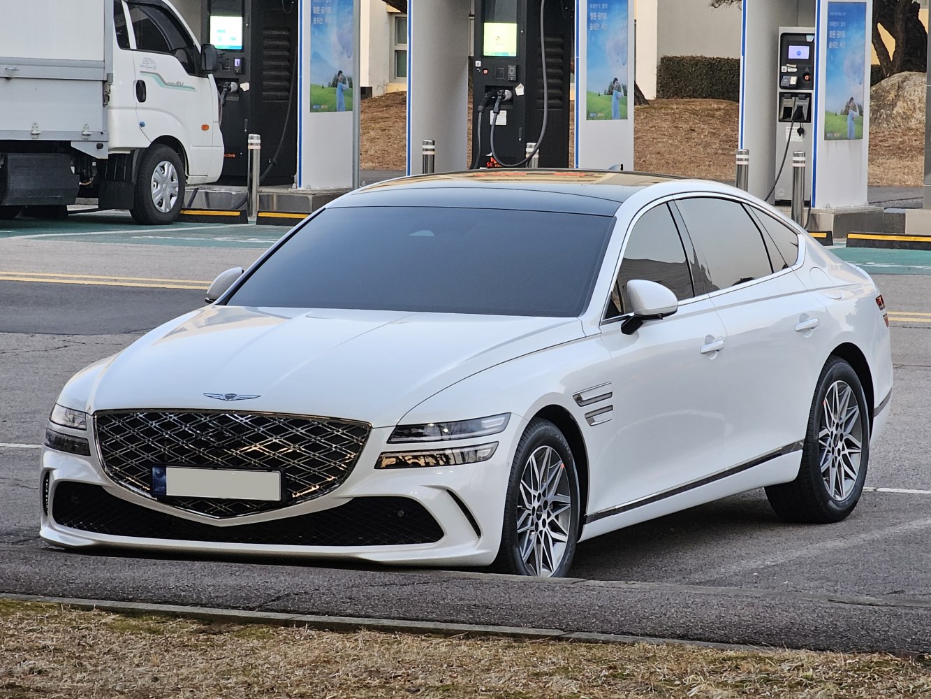 White luxury sedan with large diamond grille and dual LED headlights