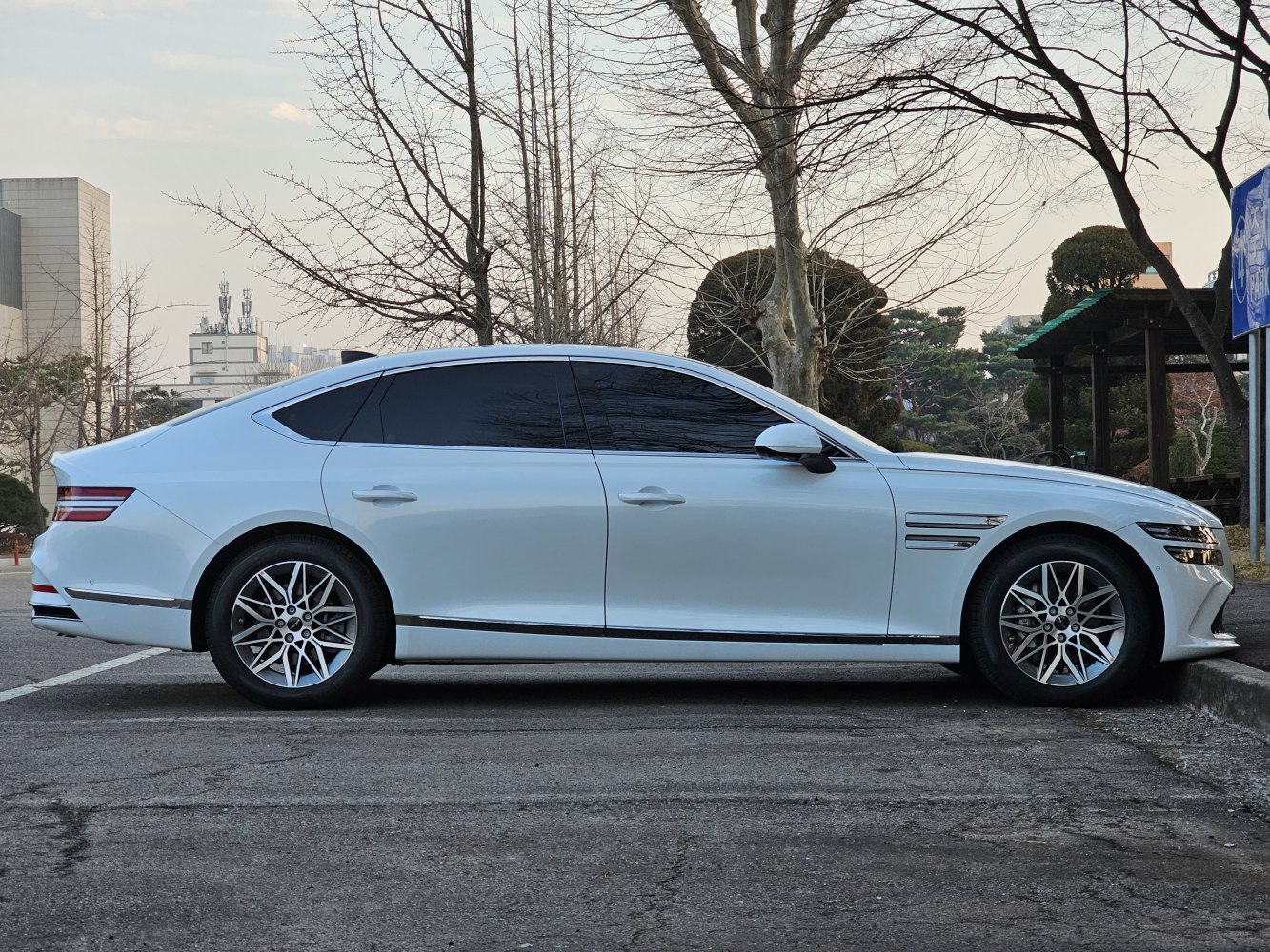 White luxury sedan with aerodynamic body and multi-spoke alloy wheels