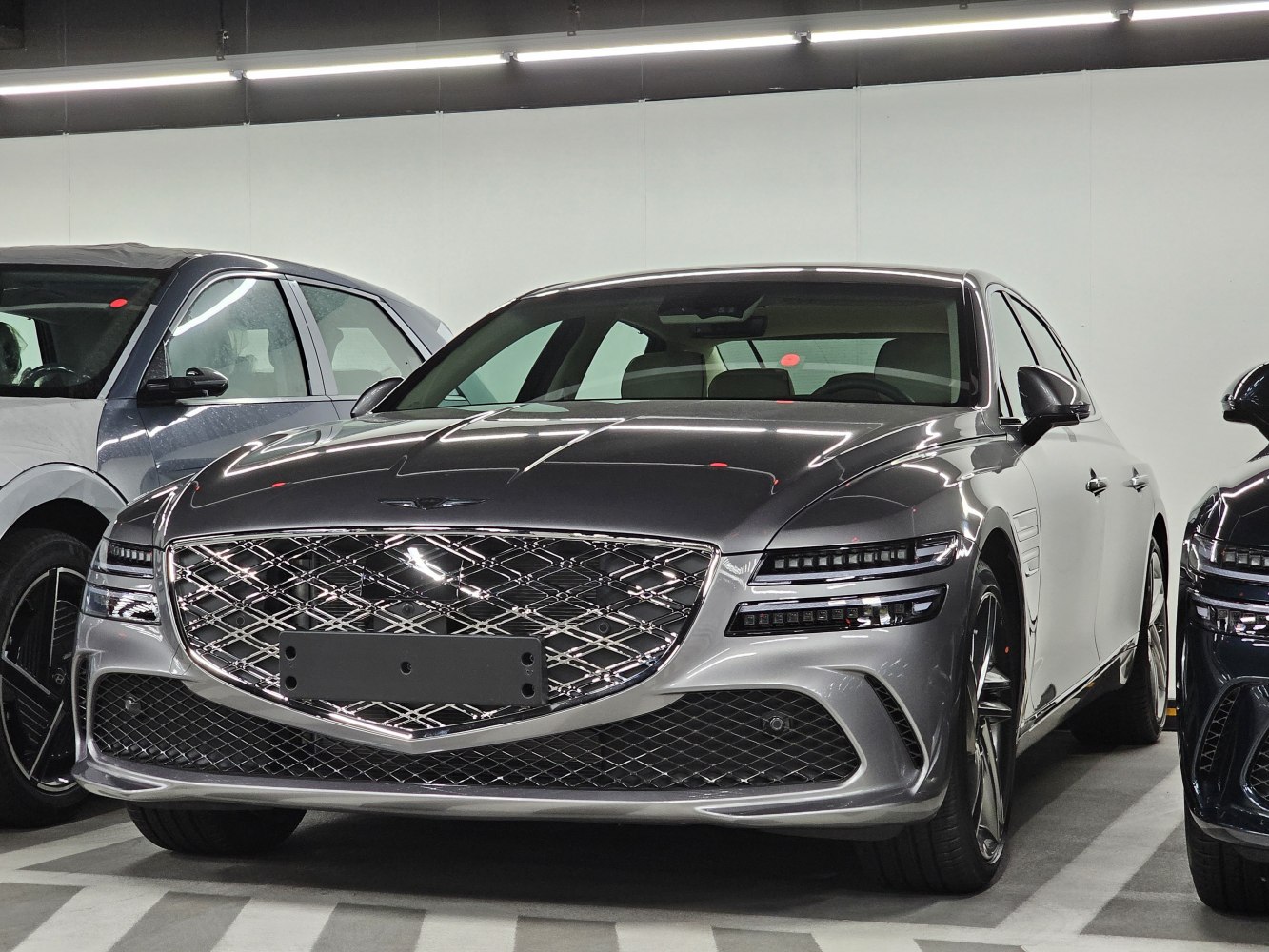 Prominent chrome grille and sleek layered LED headlights in a luxury sedan front view