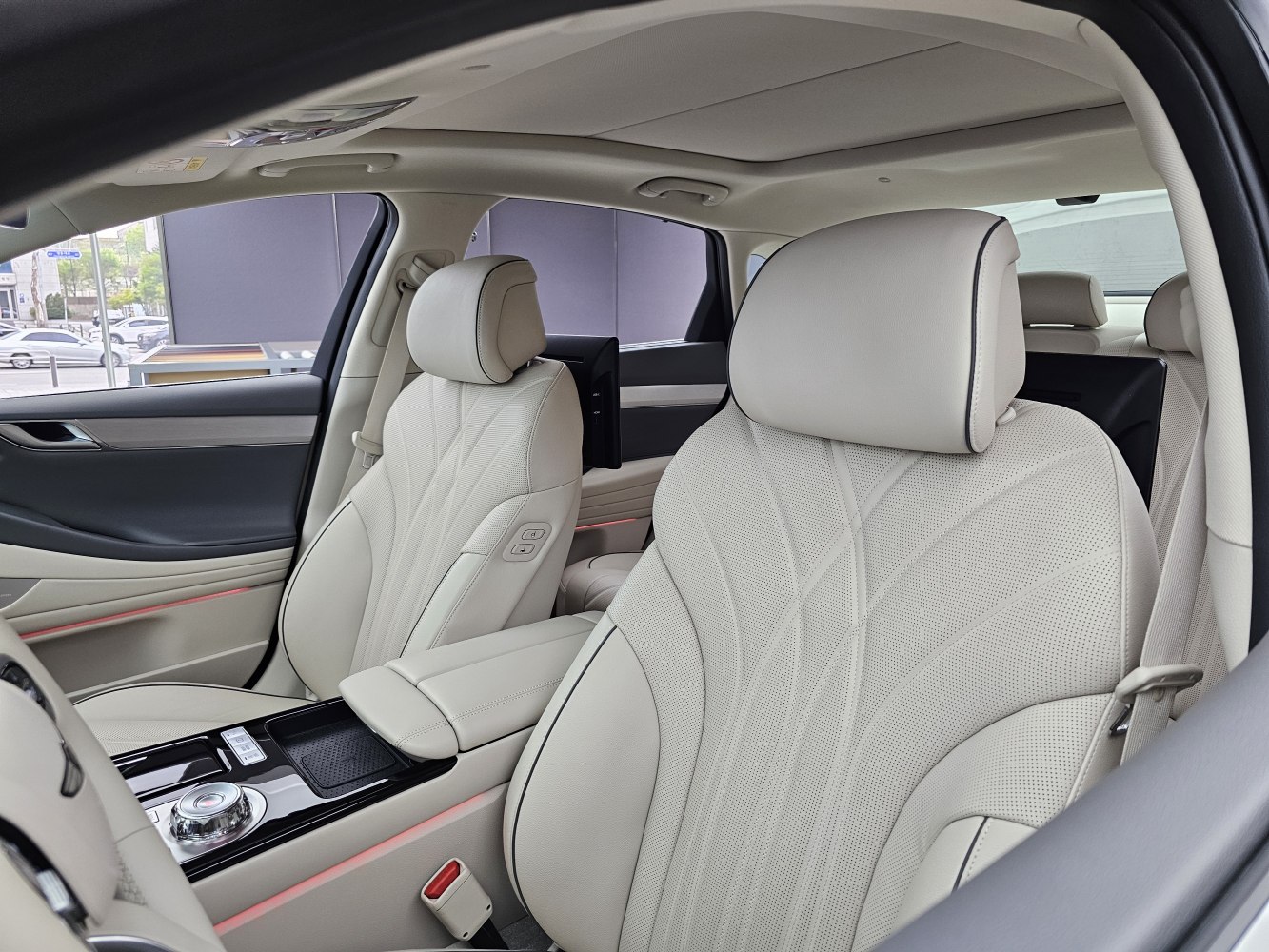 Beige perforated leather front seats with stitching and center console.