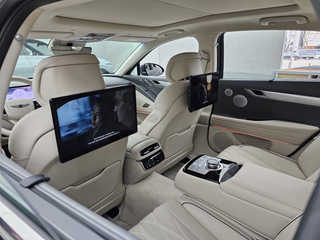 Rear interior with dual entertainment screens and premium beige leather seating