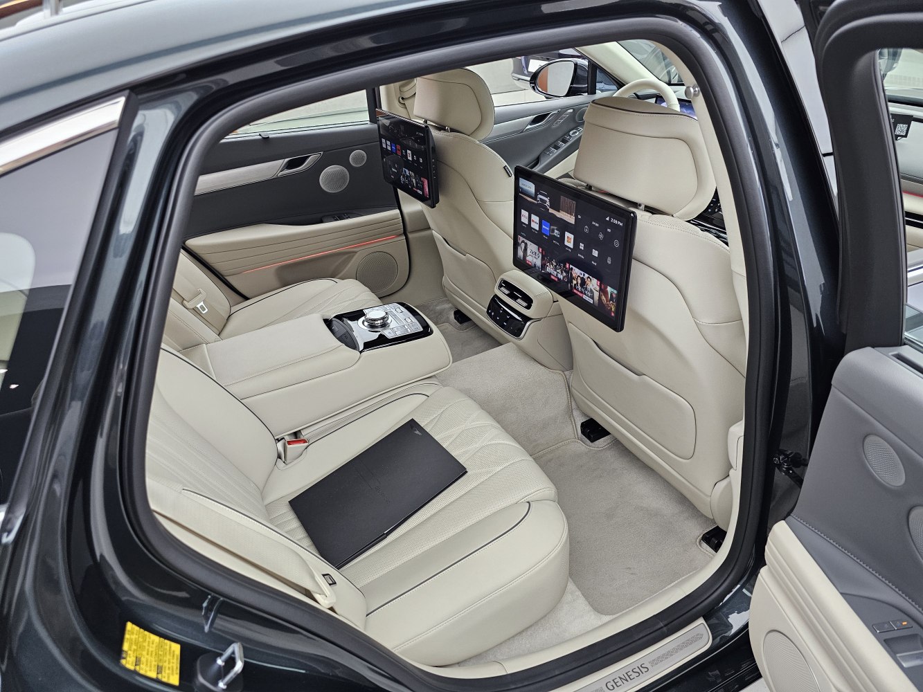 Luxury rear seat interior with dual entertainment screens and beige leather seats