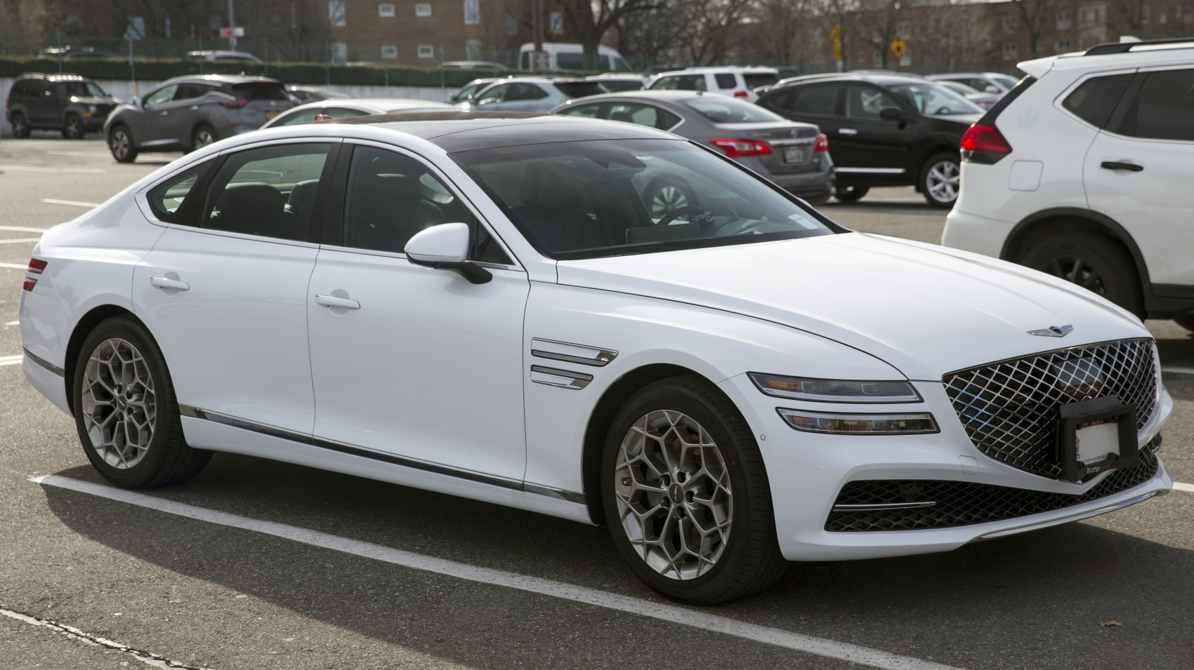 Luxury sedan with diamond-pattern grille and multi-spoke alloy wheels