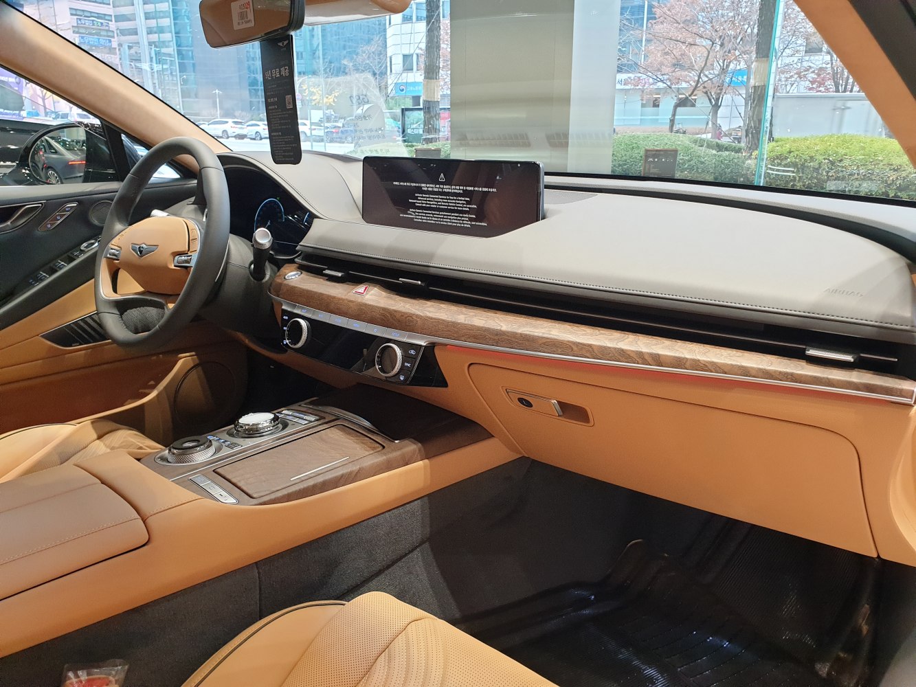 Luxury car interior with wood trim, digital display, and control knobs