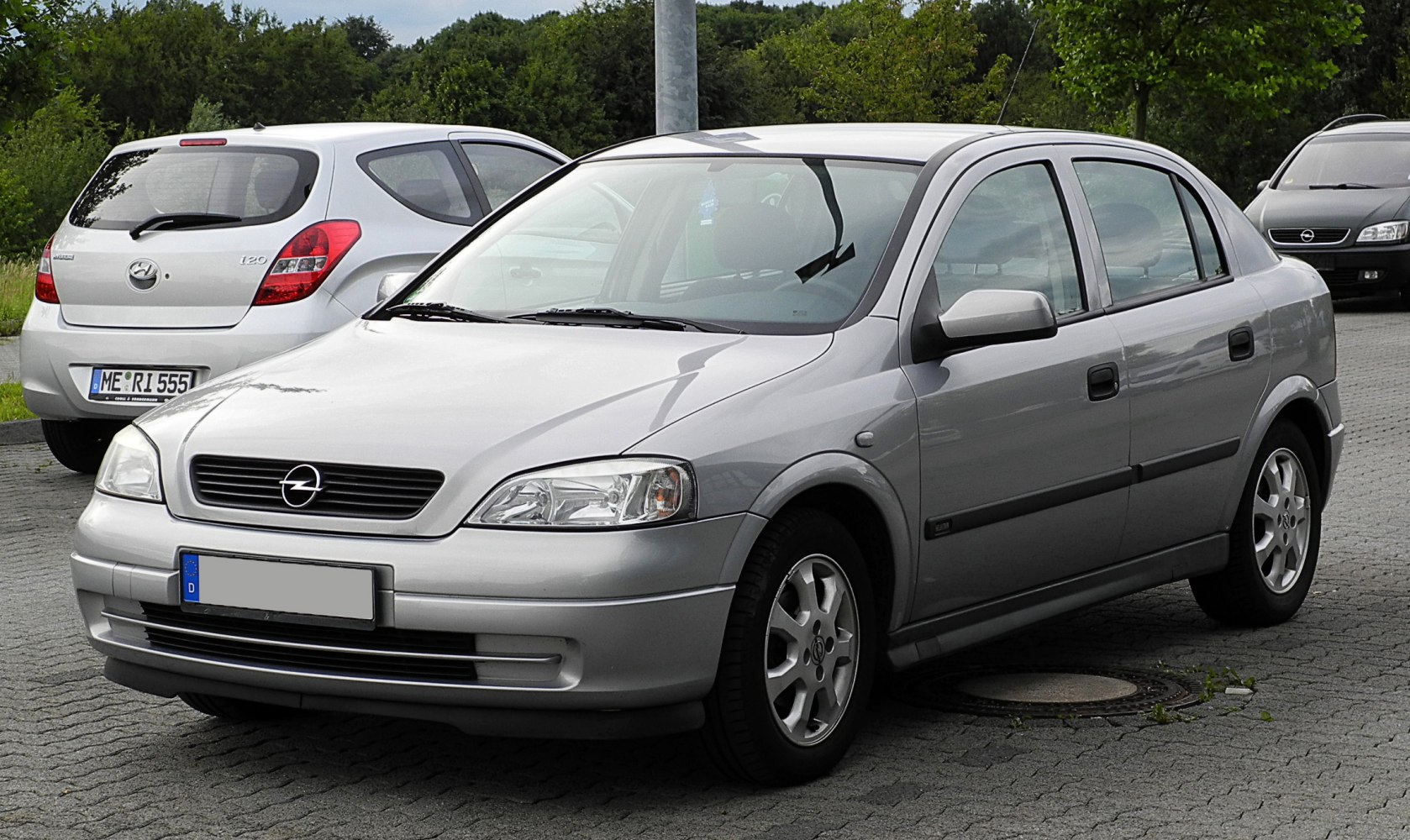 Silver compact sedan parked, front and side view