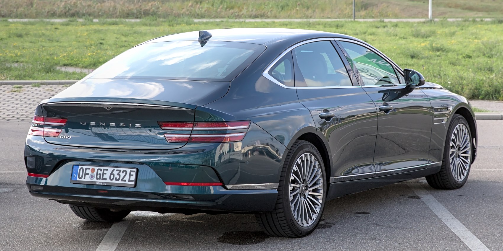 Luxury sedan rear view with sleek horizontal tail lights and sharp body lines