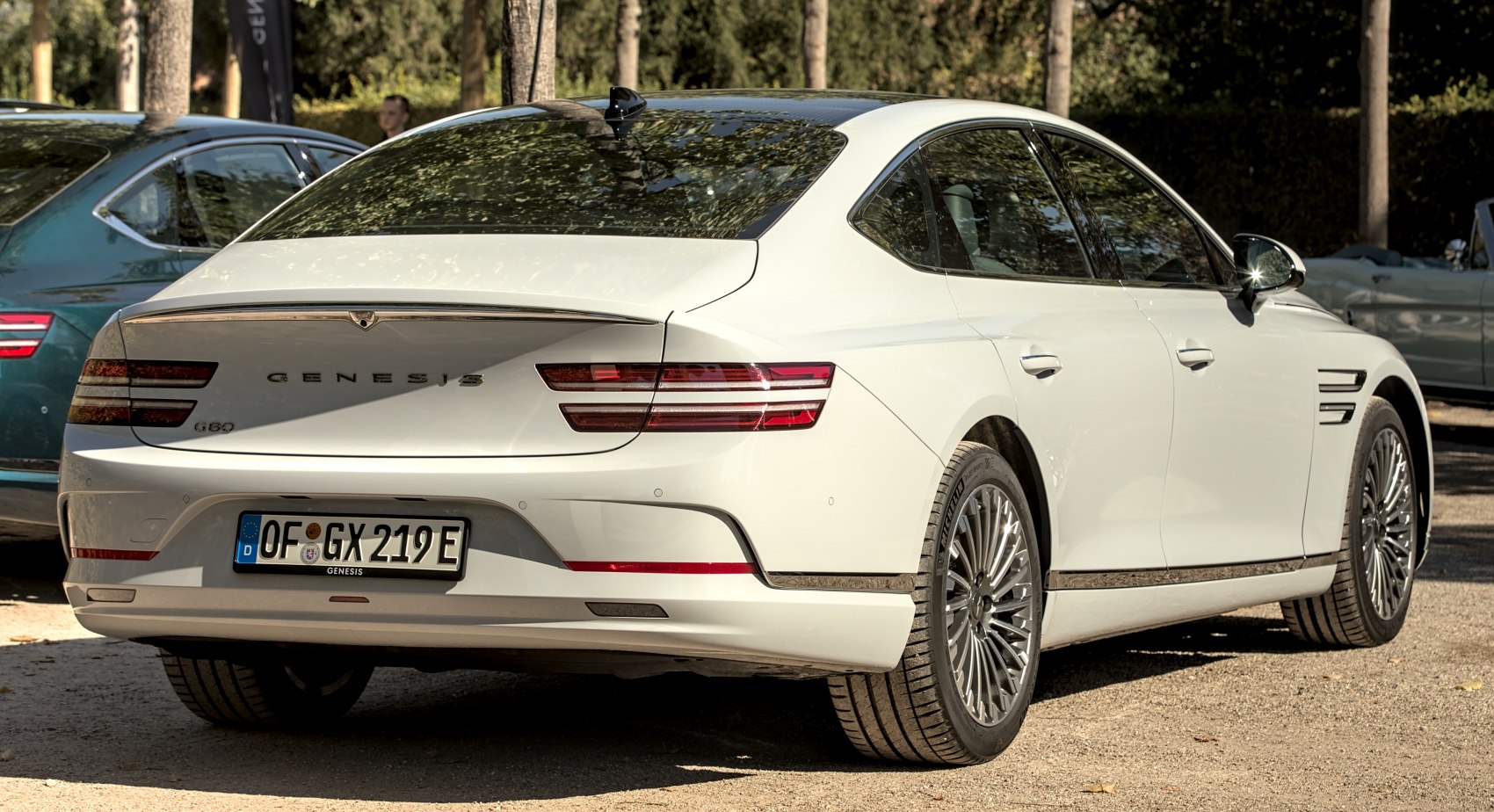 Rear view of a luxury sedan with distinctive tail lights and multi-spoke rims
