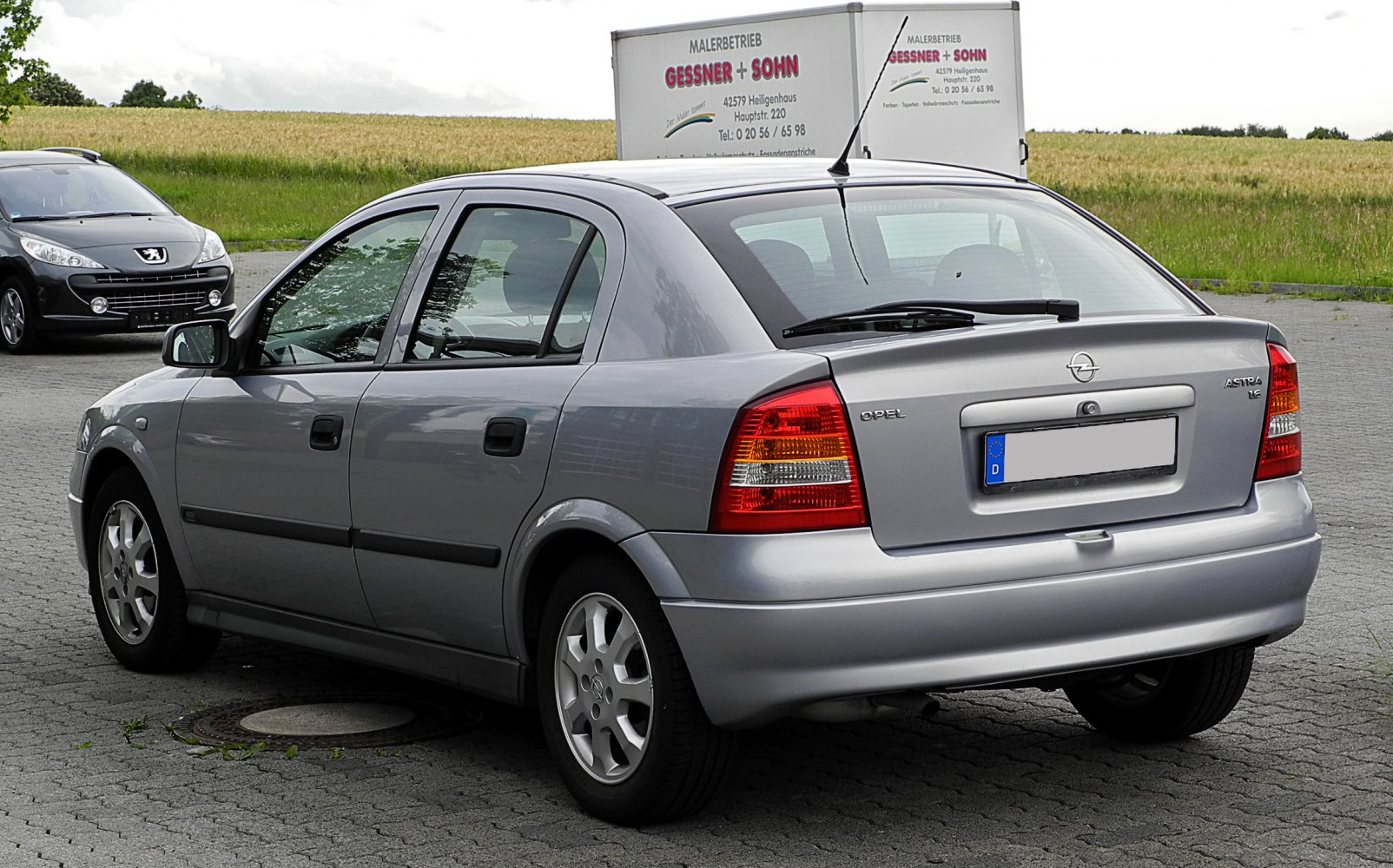 Silver compact sedan rear view with distinctive tail lights and rear wiper.