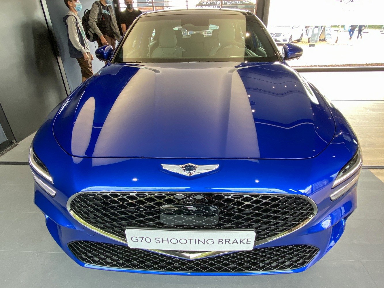 Front grille and hood design of a blue luxury shooting brake