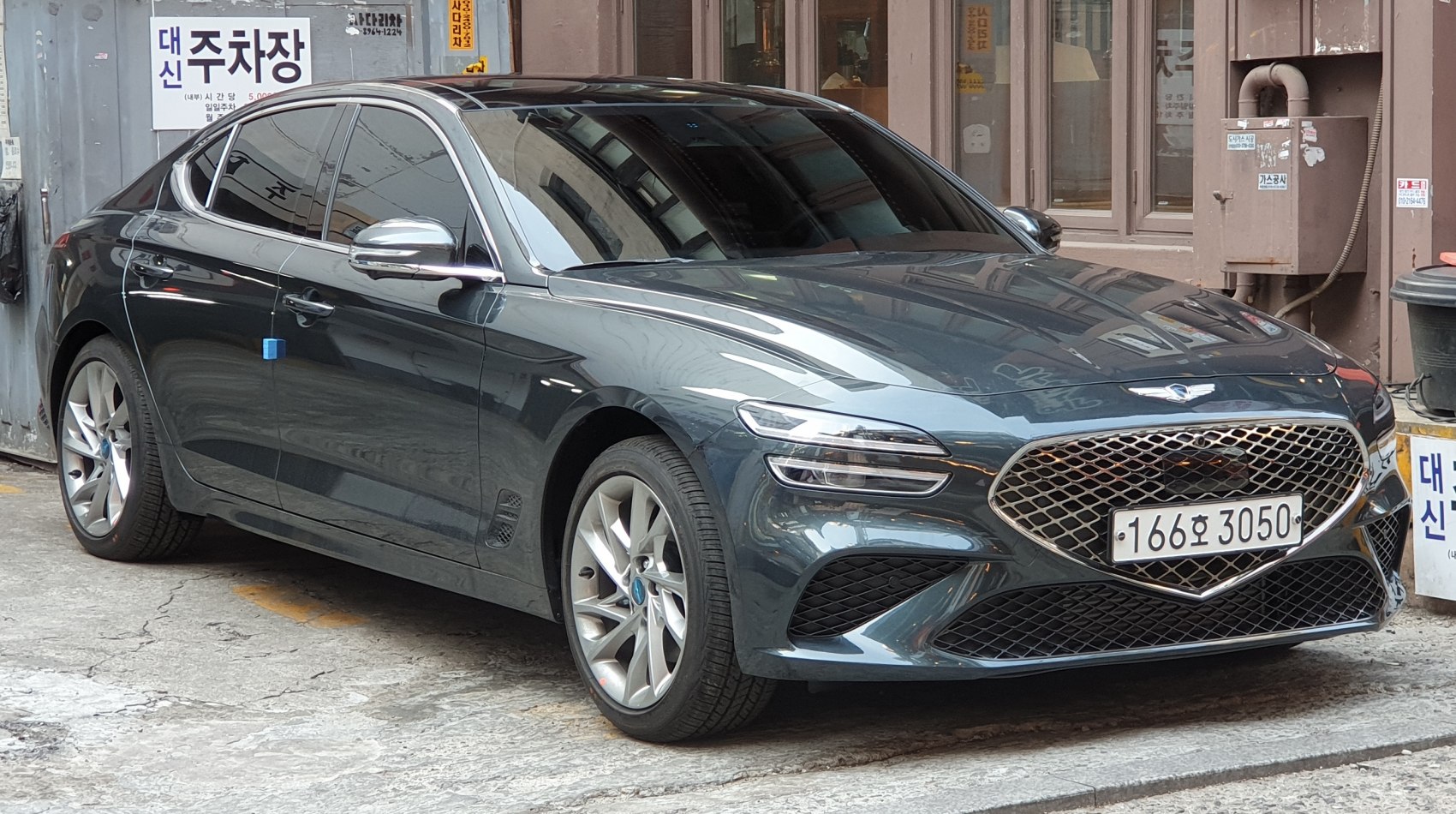 Front side view of sleek sedan with mesh grille and dynamic headlights