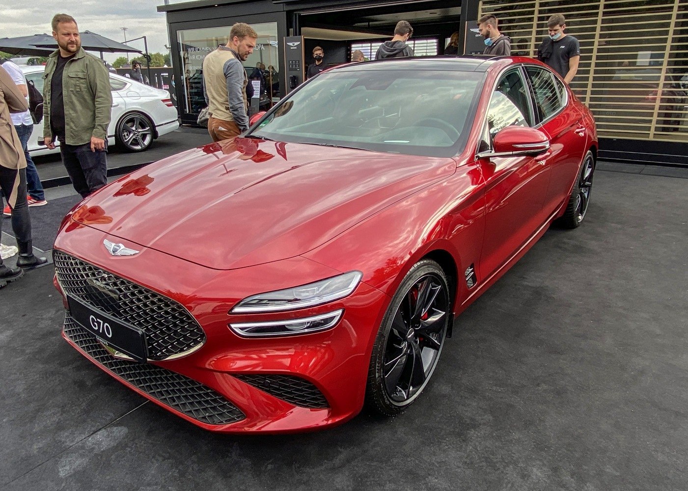 Front grille and split headlights of a red luxury sedan