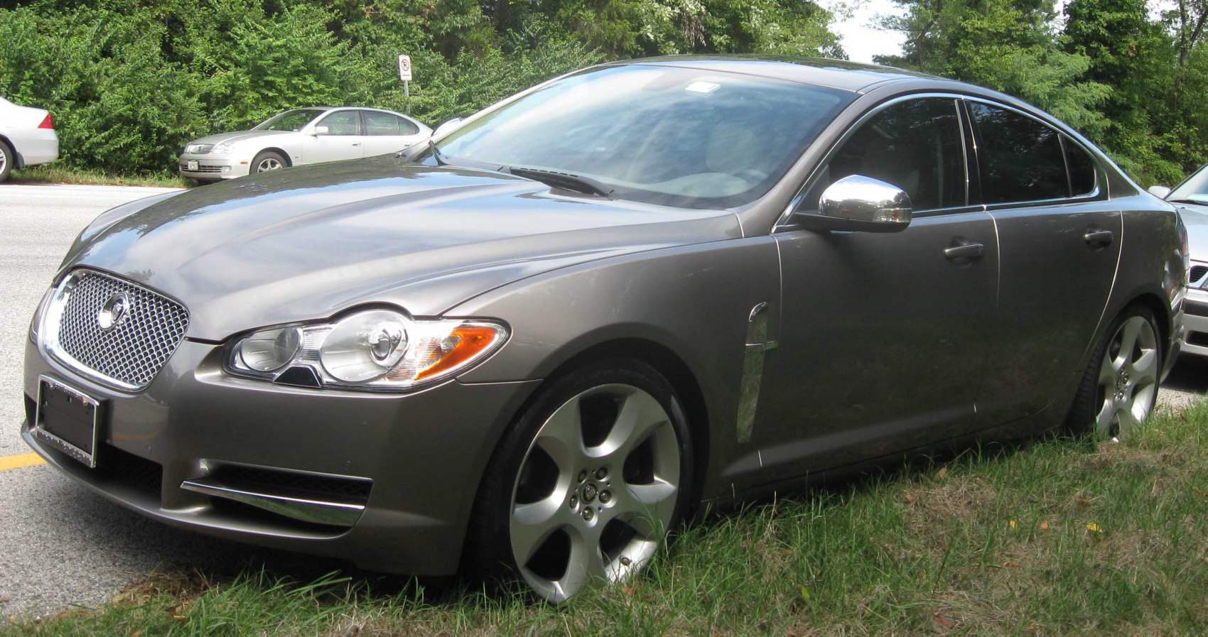 Luxury sedan front side view with iconic grille and chrome mirrors