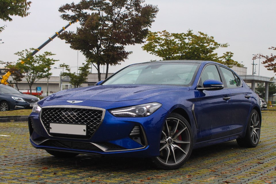 Luxury blue sedan with diamond grille and sporty alloy wheels