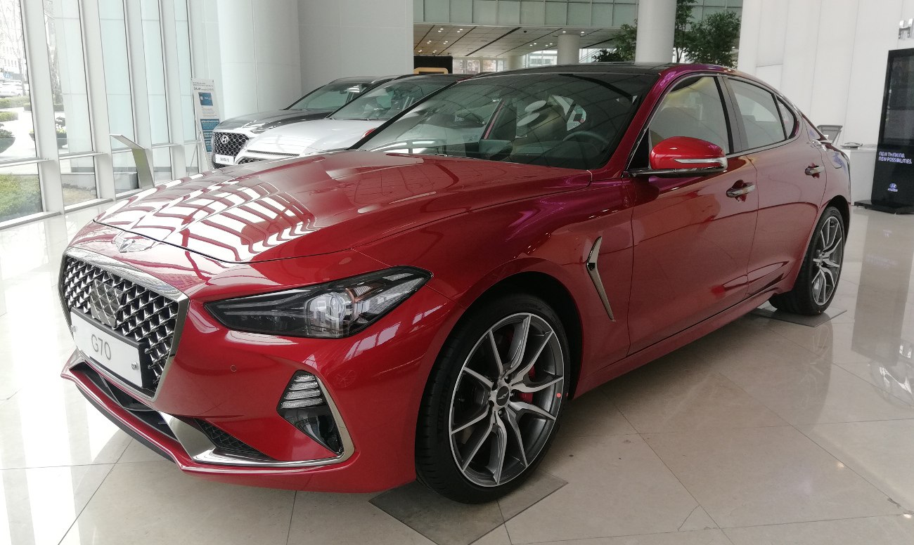 Sporty red sedan front three quarter view with alloy wheels