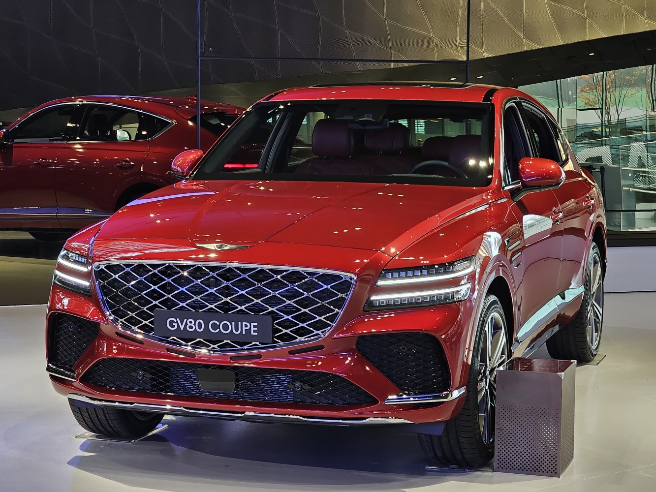 Red luxury SUV with signature grille and split LED headlights front view