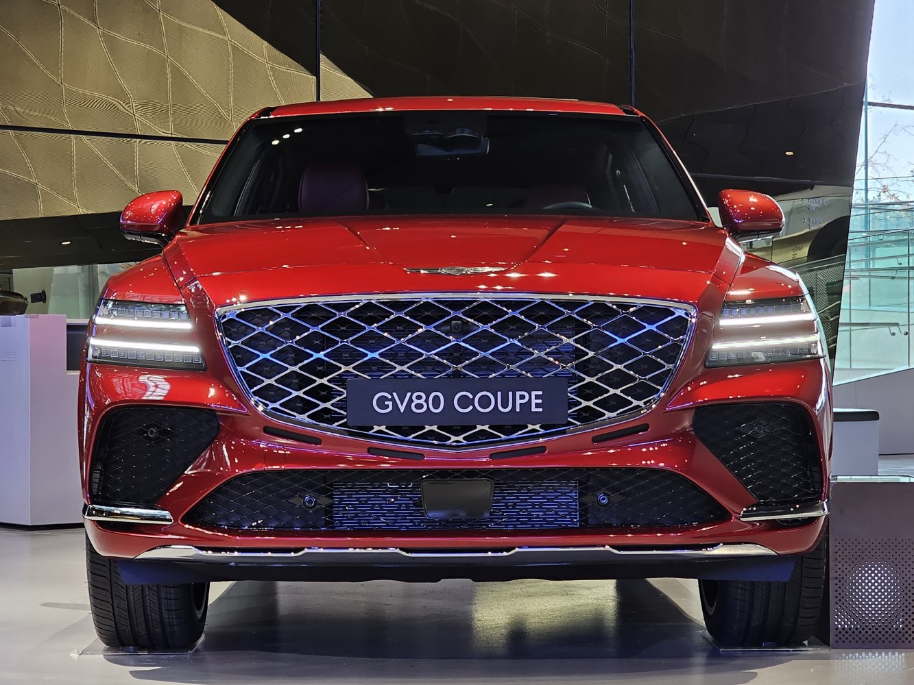Bold front grille with split LED headlights on a red luxury SUV.