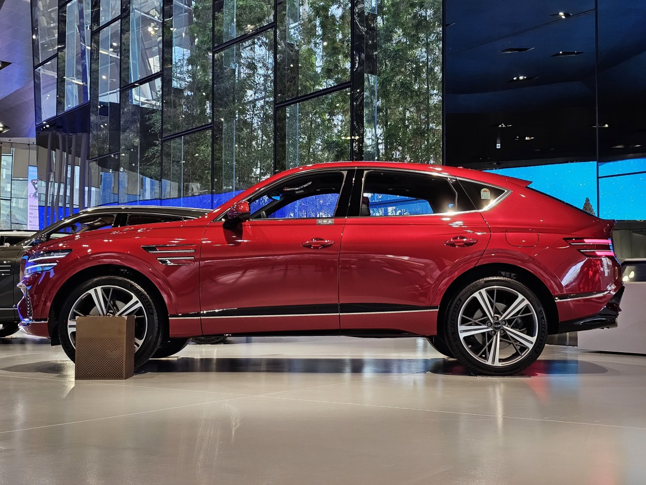 Sleek side profile of red coupe-style SUV with alloy wheels