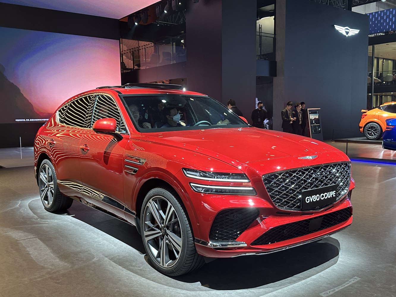 Red coupe SUV with large diamond grille and dual LED headlights