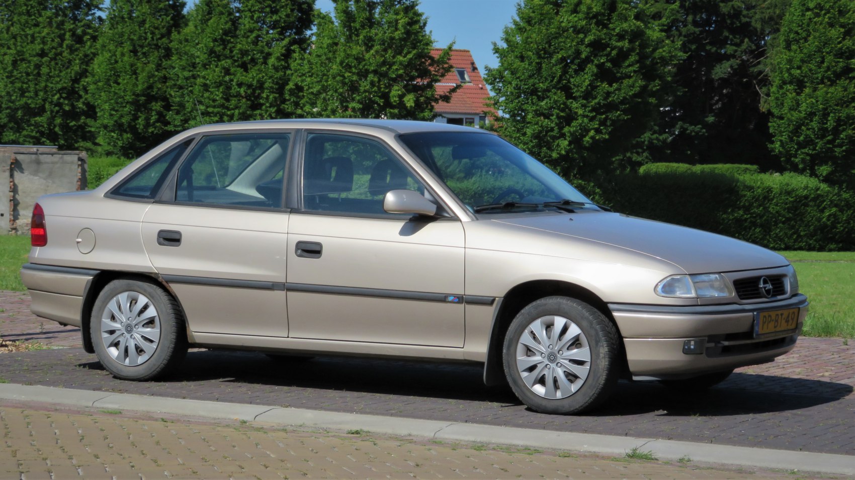 Side profile of a 1990s sedan with four doors and facelift design.