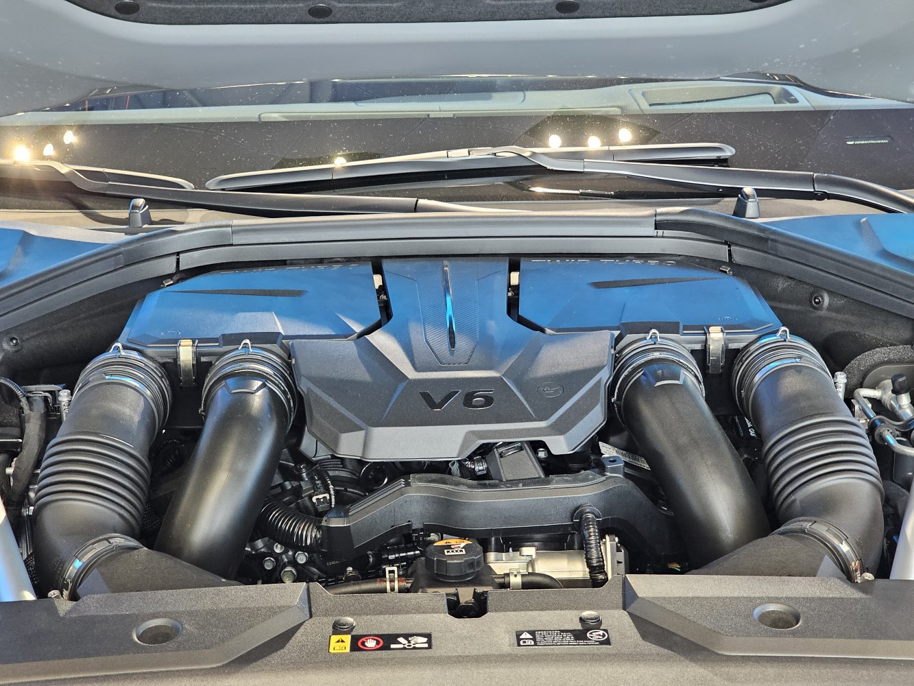 V6 engine bay with air intake hoses and engine cover