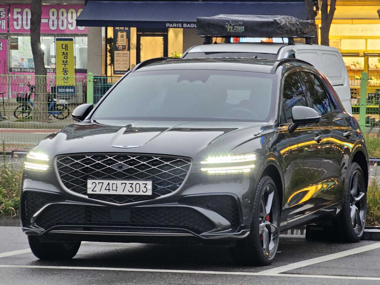 LED headlights with chrome grille and rooftop cargo box on luxury SUV front view