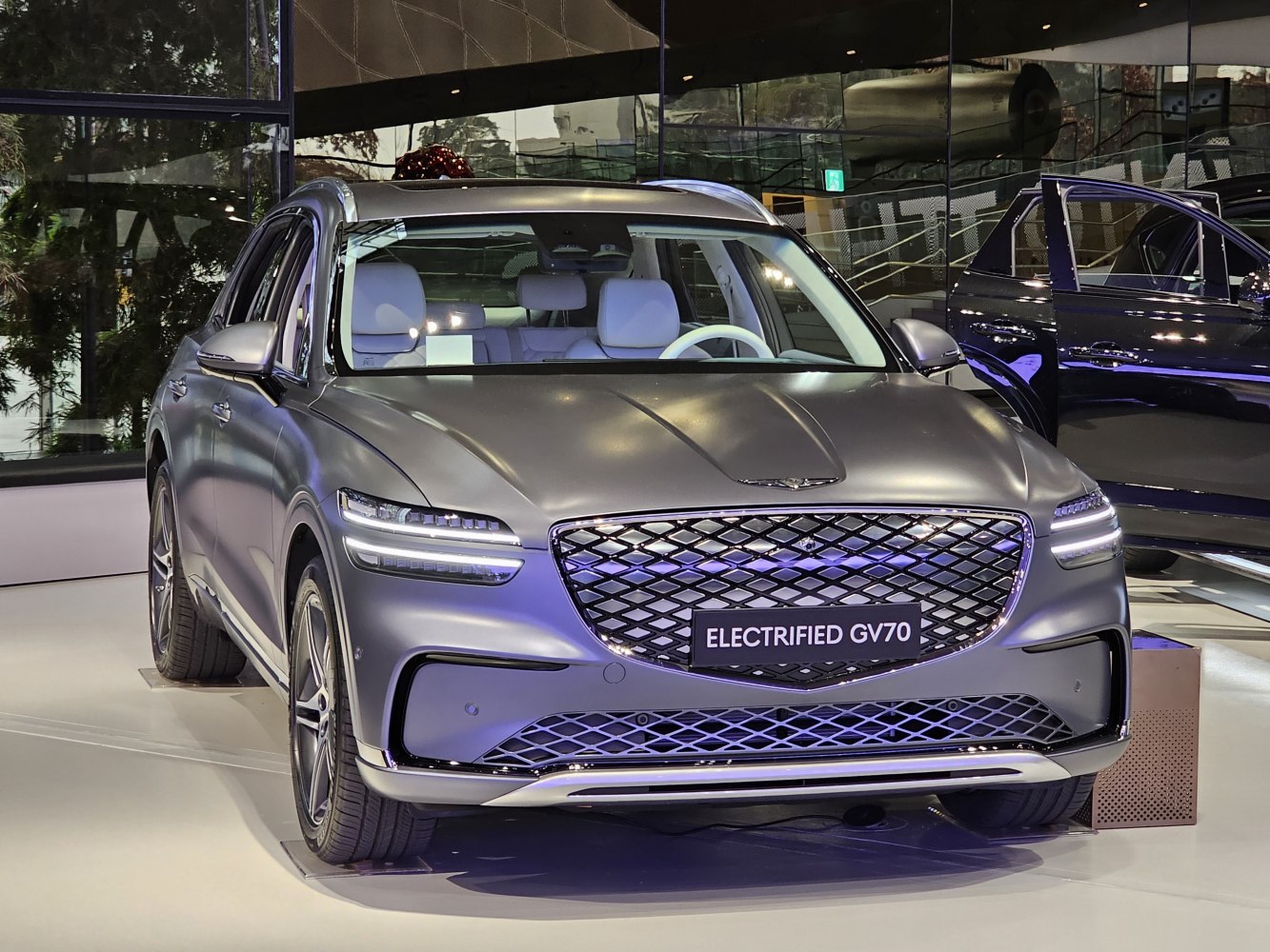 Front view of an electric SUV with LED headlights and large mesh grille