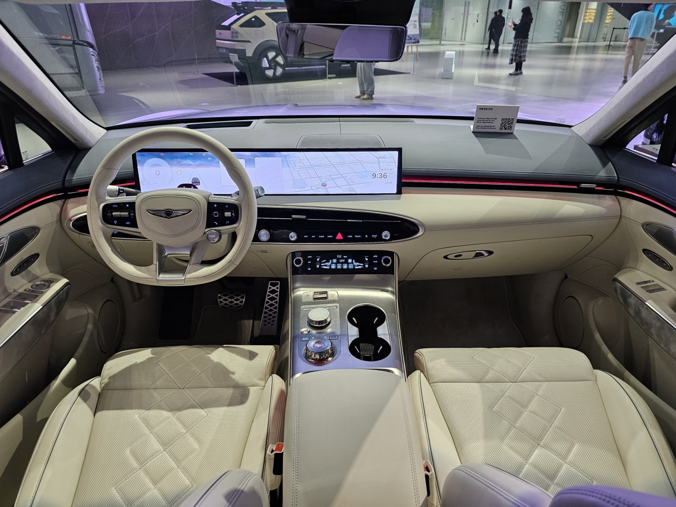 Wide digital dashboard and beige quilted leather seats in luxury SUV interior
