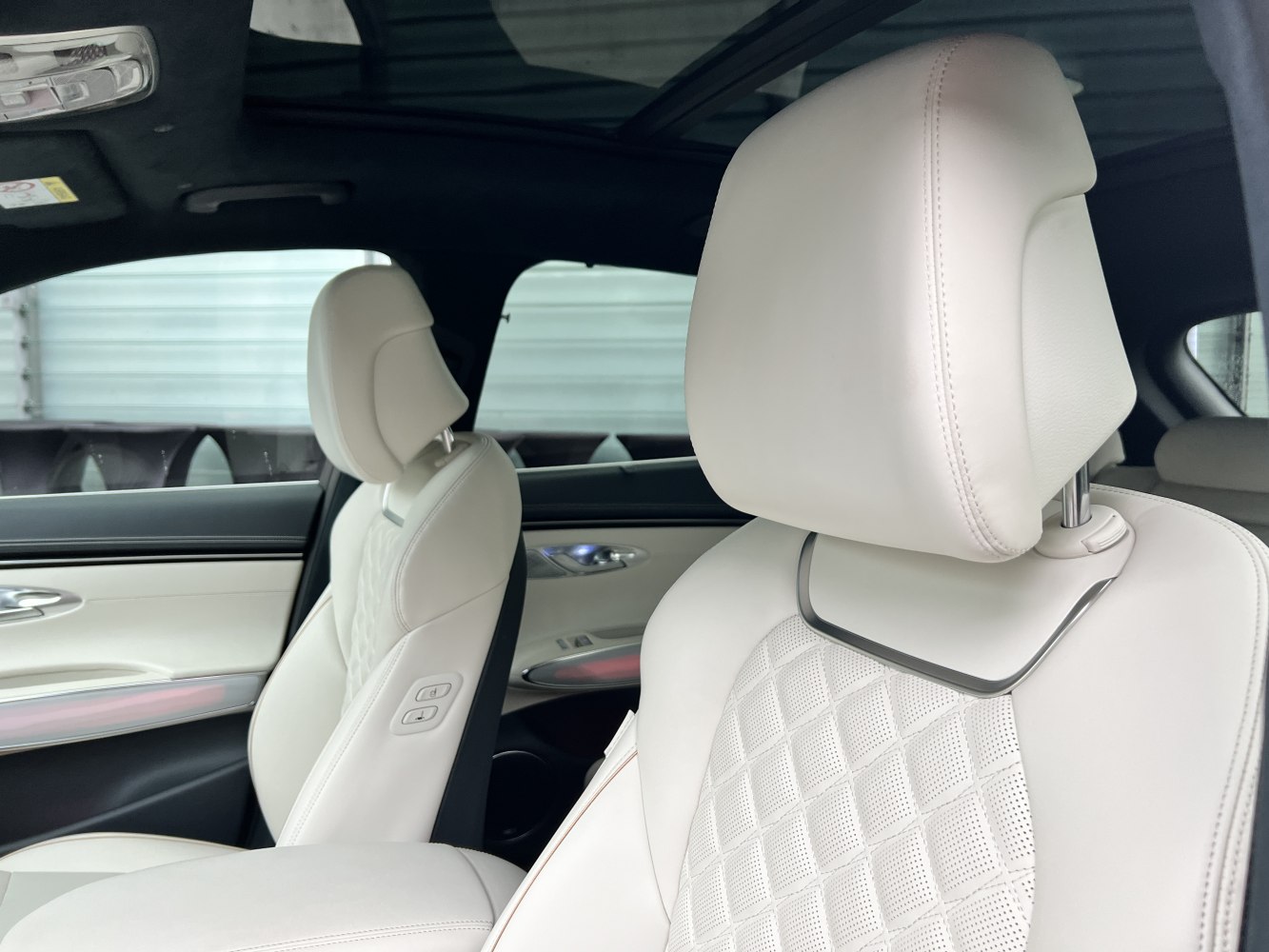 White quilted leather front seats with perforation and adjustable headrests