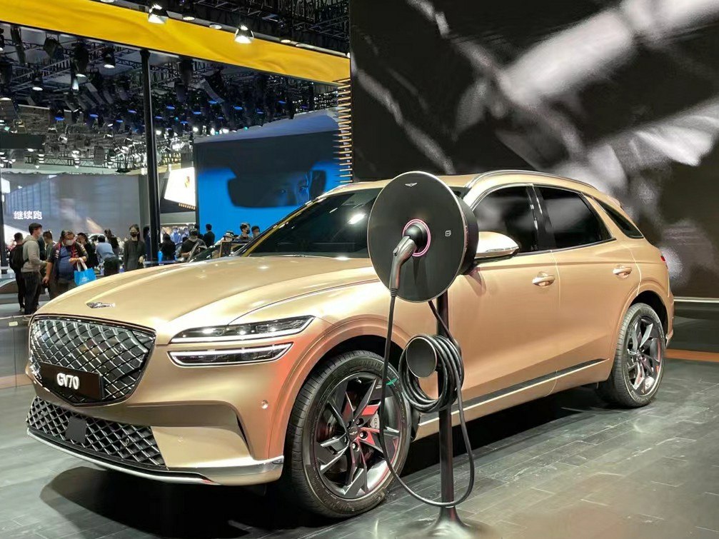 Electric luxury SUV with modern front grille and charging station