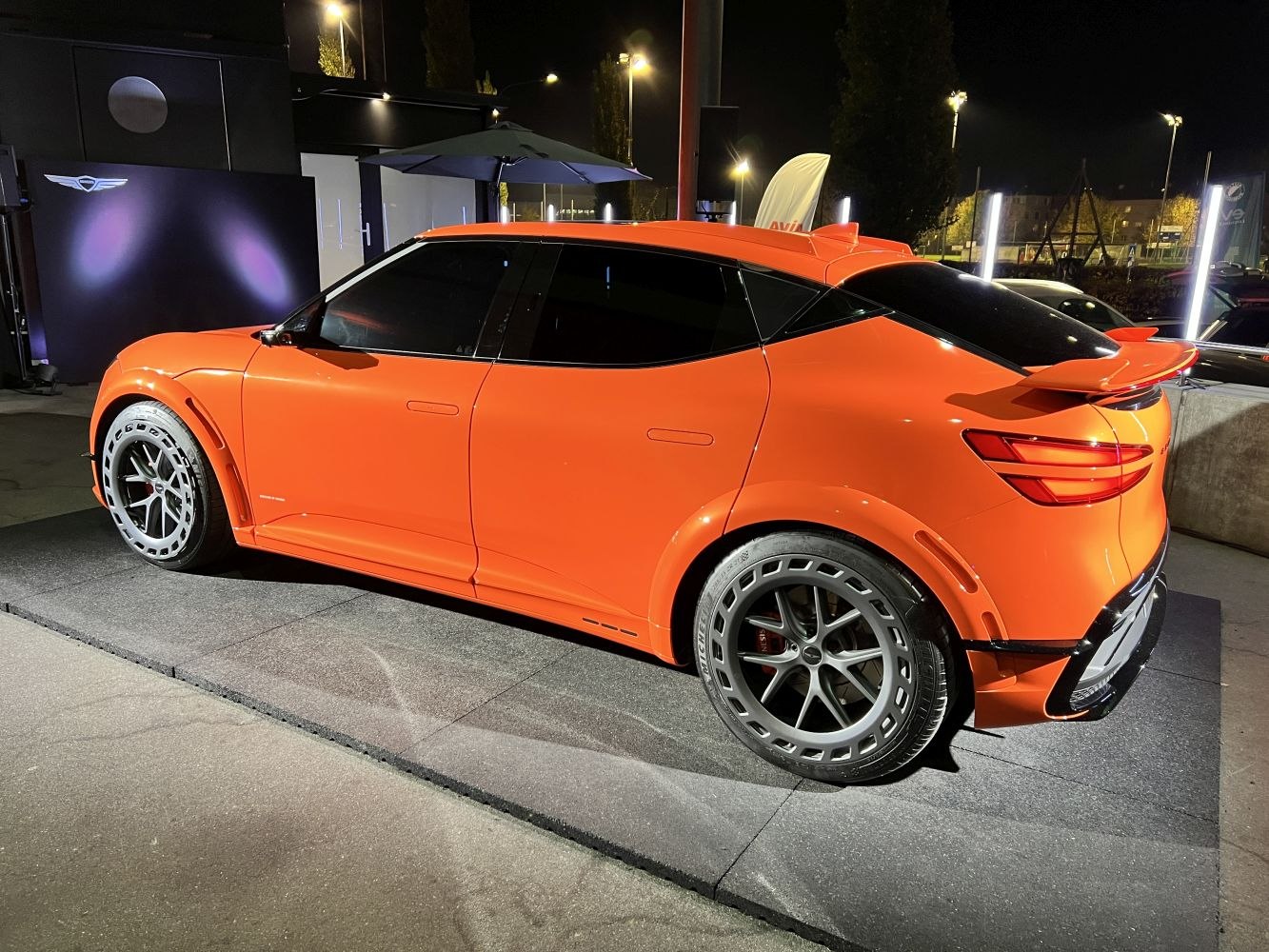 Bold orange electric SUV with wide wheel arches and rear spoiler