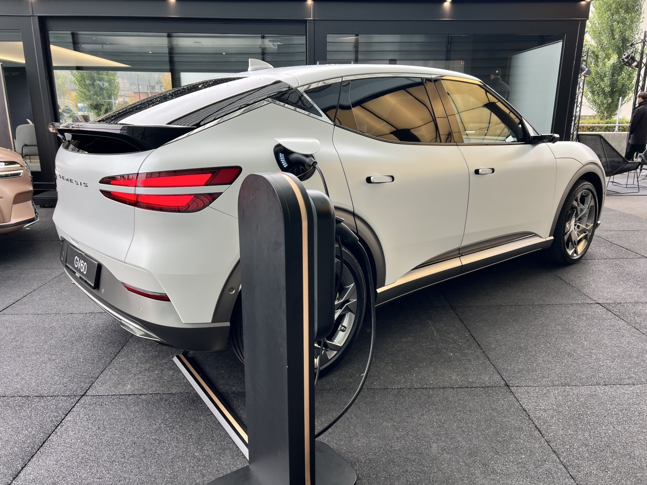 Electric SUV charging at station with sleek aerodynamic design and LED taillights