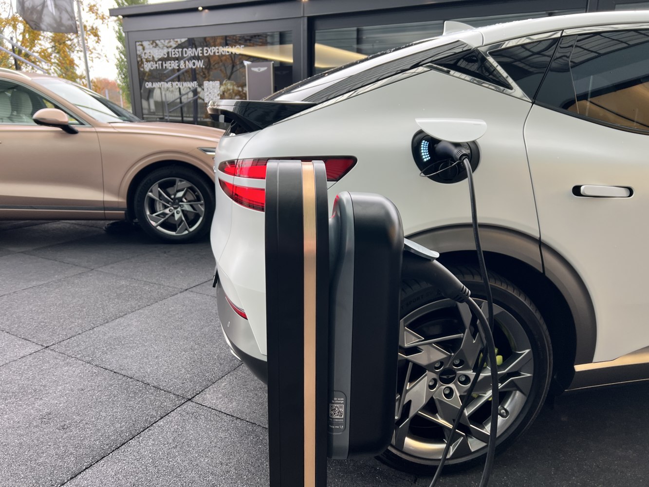 Electric SUV charging at station with rear taillights and alloy wheel design