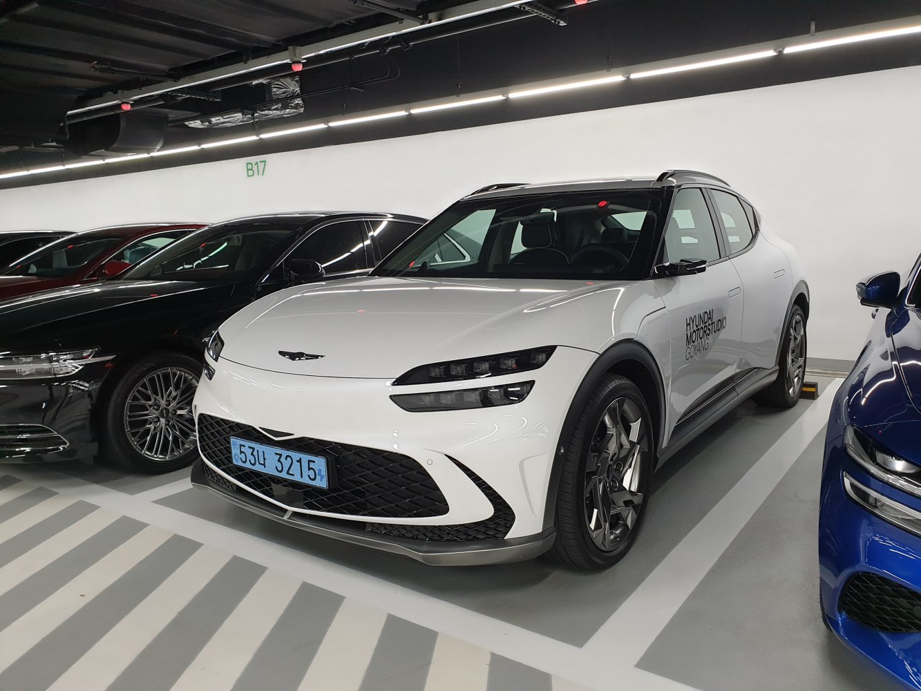 White electric crossover SUV front with sleek headlights and alloy wheels