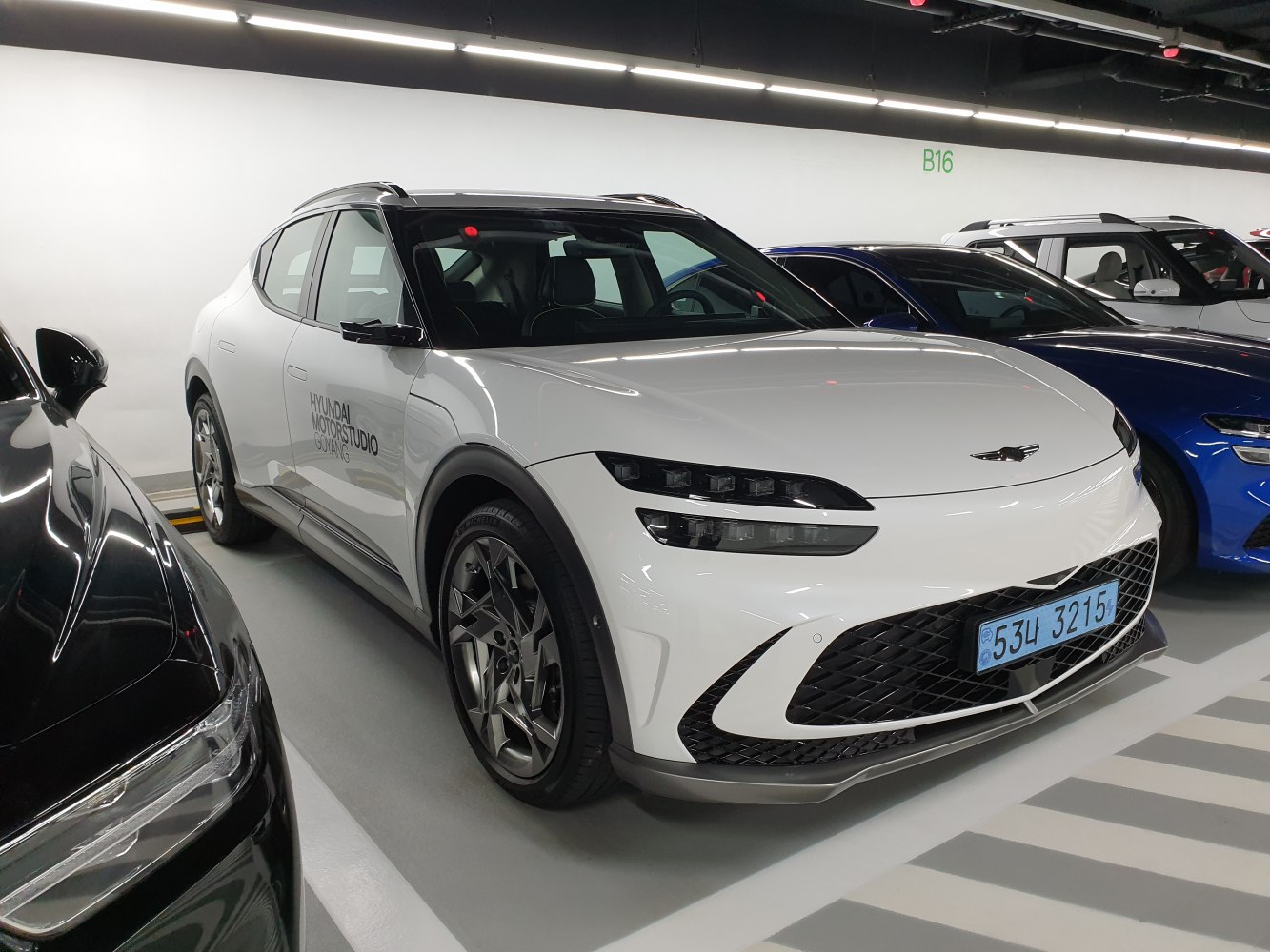 Front three-quarter view of an electric SUV with split LED headlights and a large front grille.